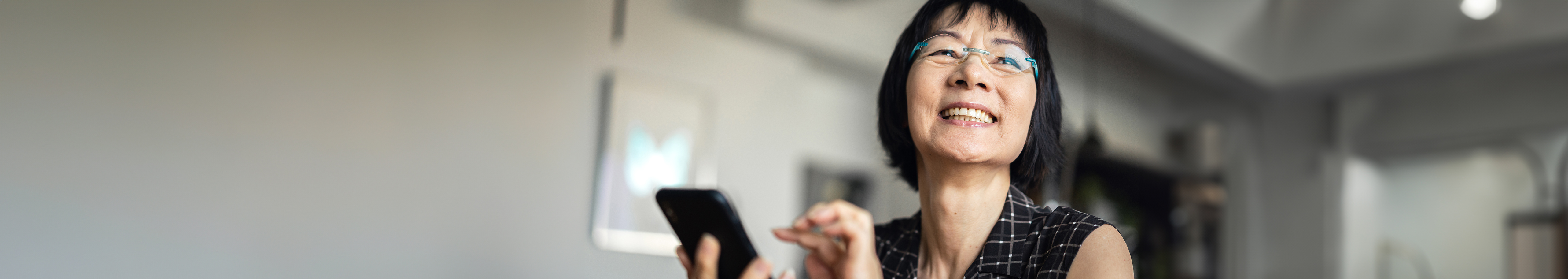 A vietnamese woman smiling holding phone